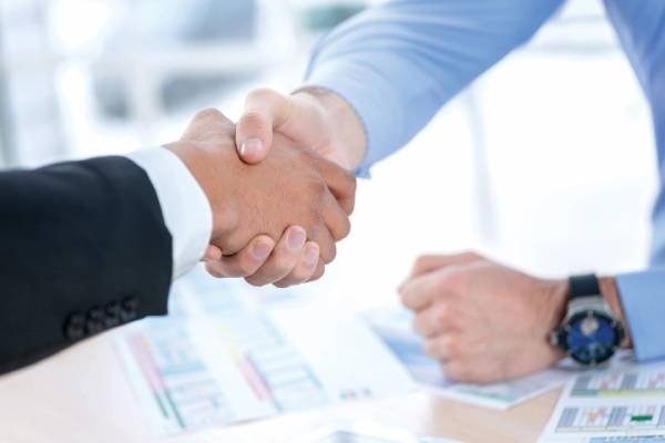 Business professionals shaking hands — trusted resume writing partnership